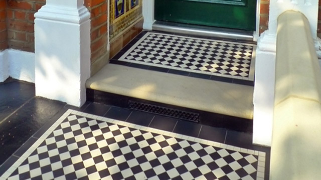 Black and White tiles in small porch, with stone threshold and glazed tile panels. Black and White path and porch tiling