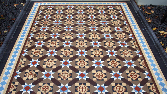 Highly decorative, multi colour, exterior Victorian mosaic tile patterned pathway features large encaustic tiles.