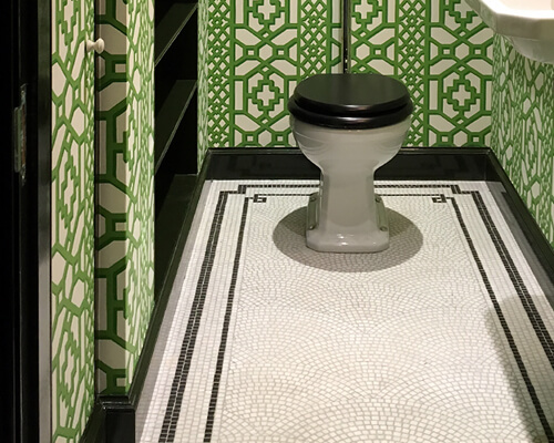 Fan motif marble mosaic with simple line border in a small cloakroom.