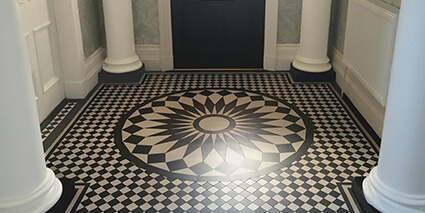 Black and White circular motif of waterjet cut tiles in traditional vestibule.