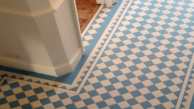 Blue and White mosaic chequerboard tiles on hallway floor.