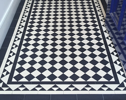 Classic black and white chequerboard design in a narrow hallway entrance floor.