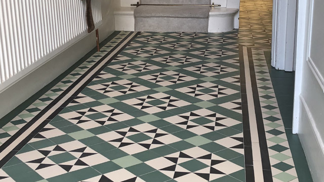 Period star and box motif geometric hallway floor design in green tones.