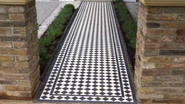 Black and white chequerboard tiles on garden path, with rope top edging to sides