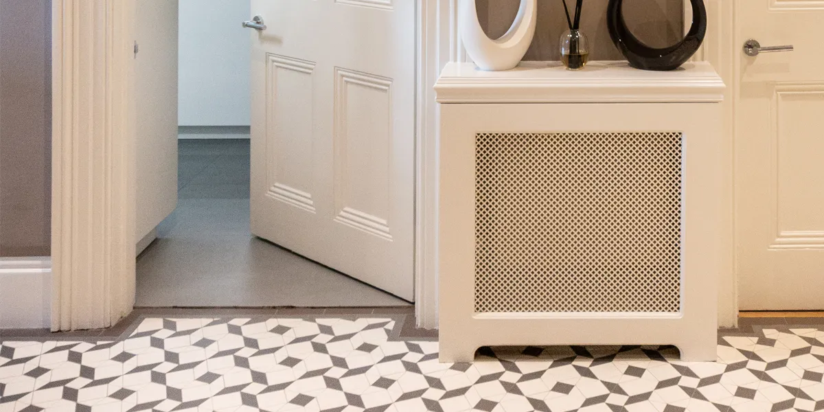 Modern mosaic tile pattern in entrance hall, with traditional radiator cover.