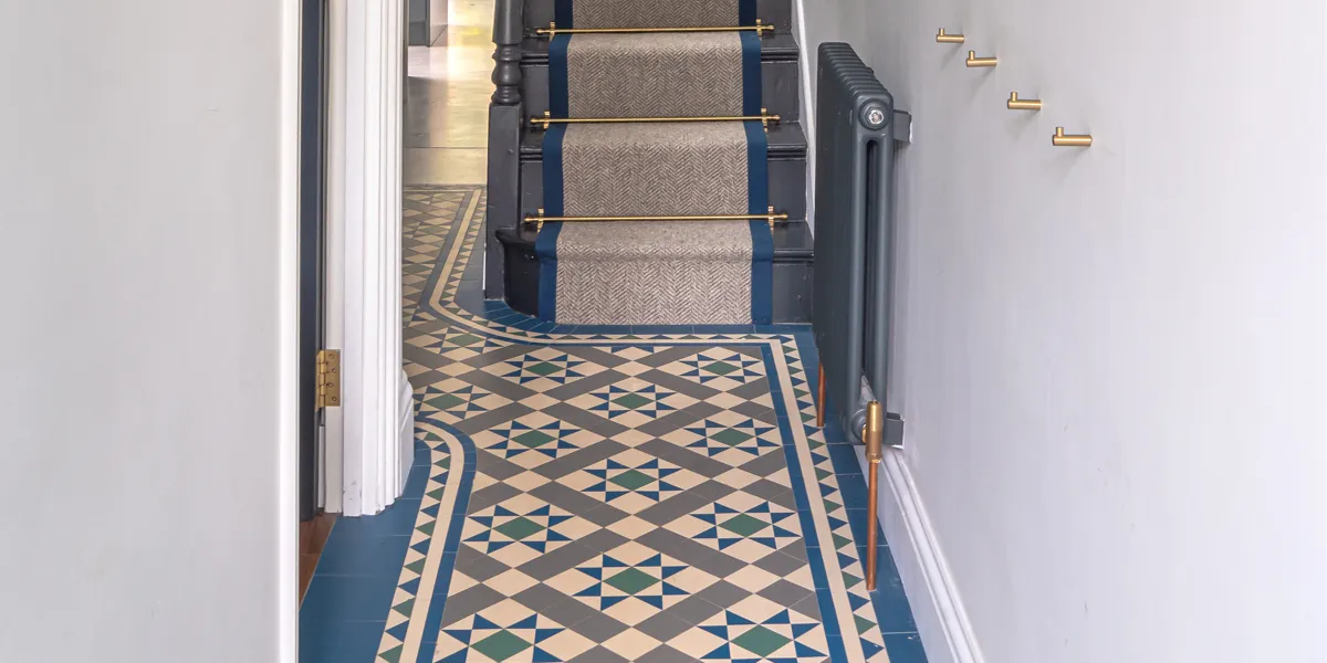 Deep blue, grey and white Victorian floor tile pattern in entrance hall.