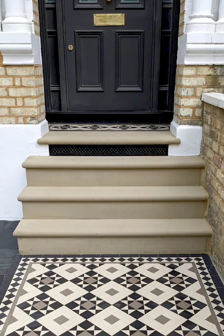 A star and box motif Victorian mosaic path and porch with york stone steps between. Beneath the top step a black painted ventilation grille.