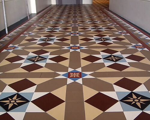 Hand cut geometric tiles and hand made period encaustic tiles in a hallway.
