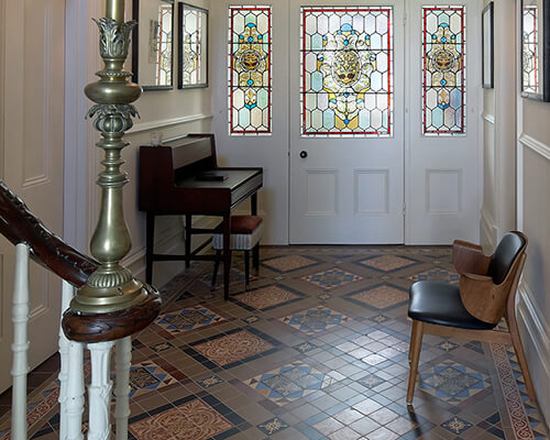 A combination of new and salvaged encaustic floor tiles in a grand entryway.
