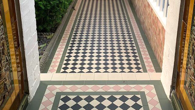 Black and White checkerboard path tiles framed with a border in pink and green.