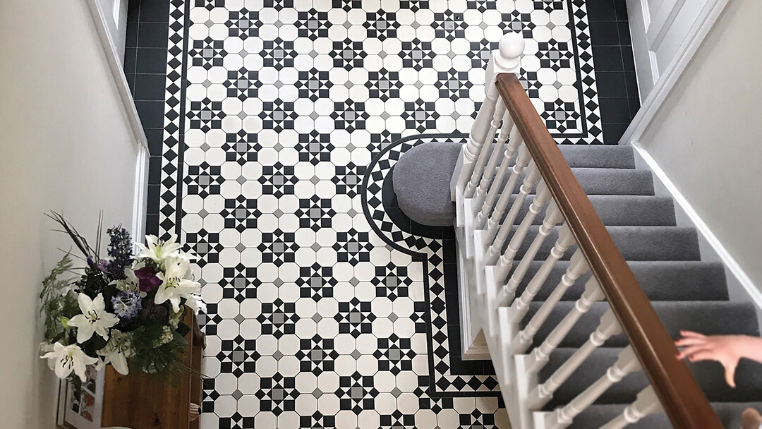 View from above of popular Victorian tile design, featuring a set of white octagons and star motif in black and grey.