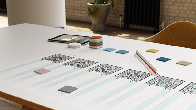 Colour tile samples and Victorian pattern options laid out on design studio desk