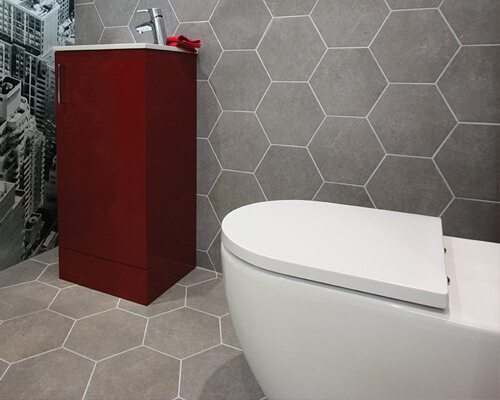 Grey hexagon tiles on walls and floor of modern WC.