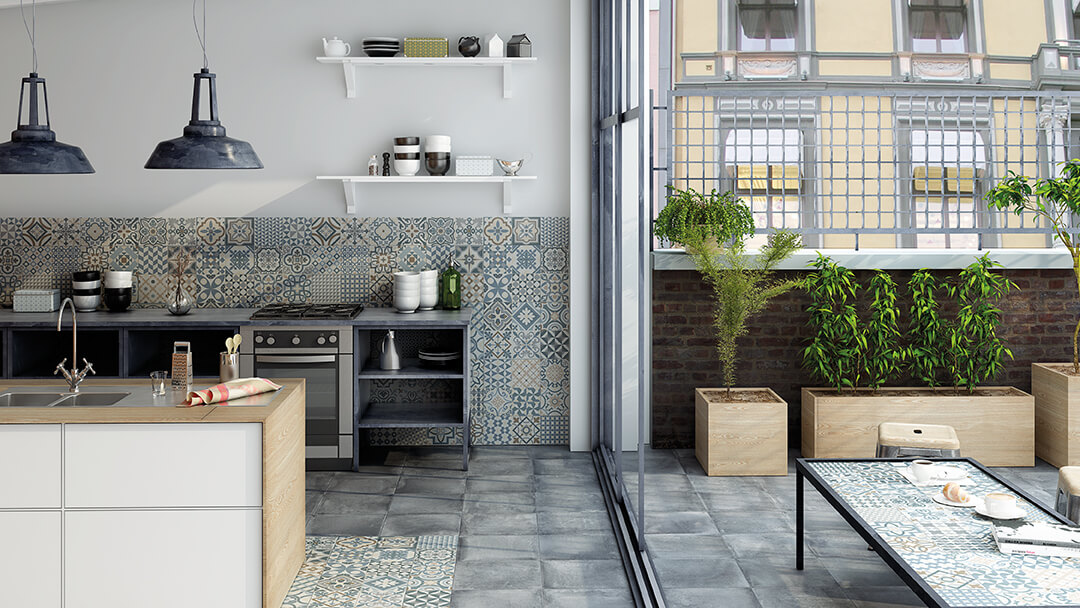 Modern kitchen leading to outdoor balcony featuring patchwork printed encaustic style tiles.