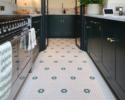 Contemporary kitchen featuring a floor of 25mm super white hexagons with a dark green floral motif.