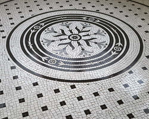 Art Nouveau influenced circular motif of marble mosaic for a bathroom floor.