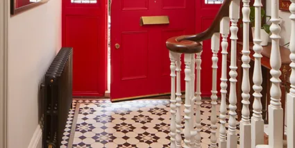 Victorian hallway tiles and large red doow.