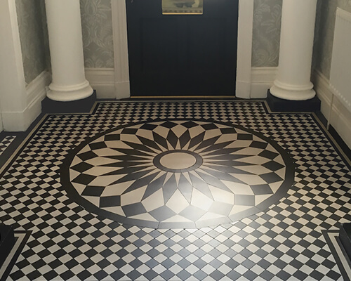 Custom cut, circular black and white ceramic tile motif in centre of large vestibule.